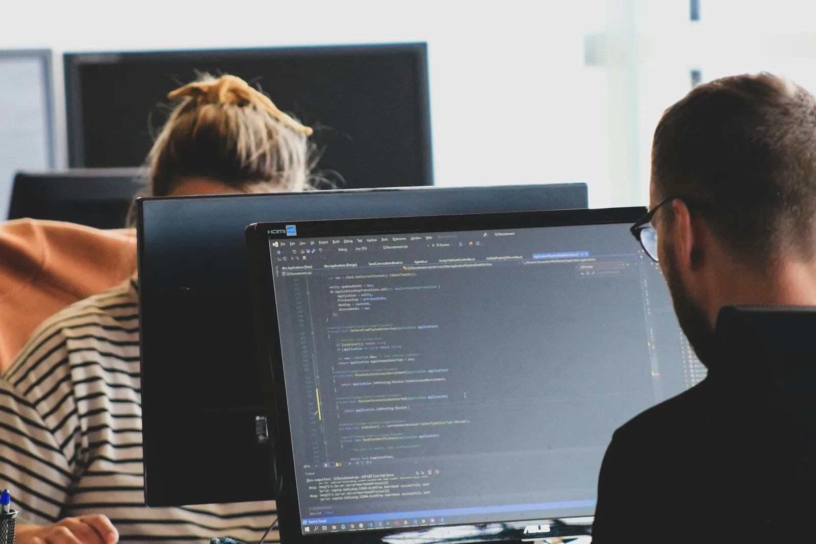 Deux développeurs travaillent sur du code à l’écran